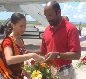 Minister Meriton hands over the basket of flowers to singles gold medallist Ah-Wan